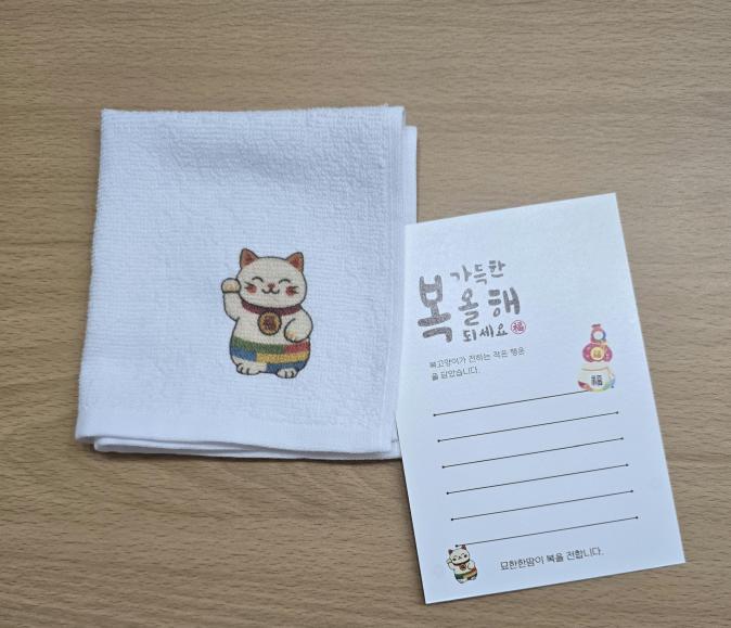 Hand towel and postcard products featuring the Bok Cat character